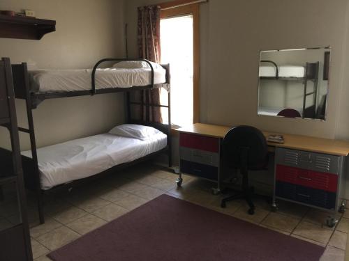 a room with bunk beds and a desk and a mirror at Avenues Hostel in Salt Lake City