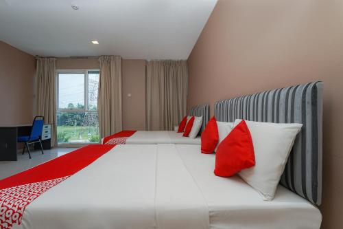 a bedroom with a large bed with red and white pillows at Super OYO 90729 New Bangi Gateway Hotel in Bangi