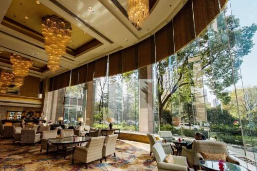 a hotel lobby with chairs and tables and large windows at Shangri-La Wuhan,Close to The Mixc with three subway lines in Wuhan
