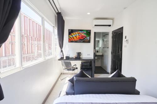 a bedroom with a bed and a desk in a room at Thonglor Suites Hotel in Bangkok
