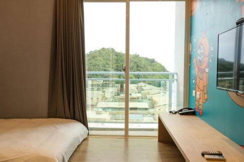 a hotel room with a bed and a large window at Taitung Railway Inn in Taitung City