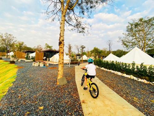 a child riding a bike next to a tree at The Wild Khao Yai in Klang Dong