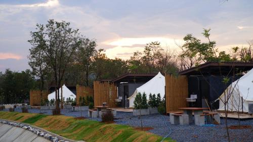 a row of white tents in a park at The Wild Khao Yai in Klang Dong