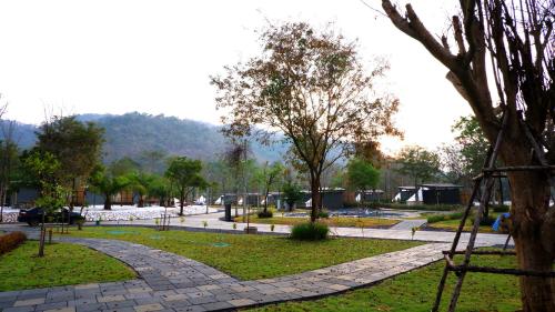 a park with a stone walkway and a tree at The Wild Khao Yai in Klang Dong