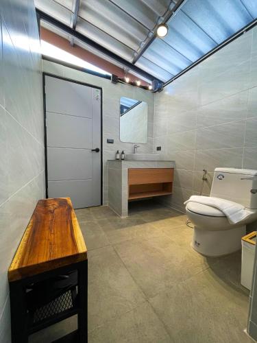 a bathroom with a toilet and a sink at The Wild Khao Yai in Klang Dong
