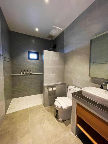 a bathroom with a toilet and a sink at The Wild Khao Yai in Klang Dong