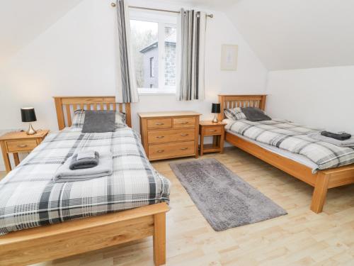 a bedroom with two beds and a window at Ty Coch in Llanberis