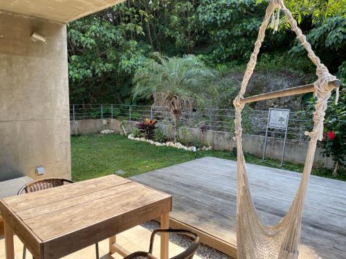 a porch with a wooden table and a hammock at ビーチ目の前プライベートヴィラ KafuwaNanjo in Azama