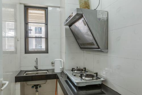 a kitchen with a sink and a microwave at WESU Light Luxury Apartment Shenzhen Nanshan Science Park Branch in Shenzhen