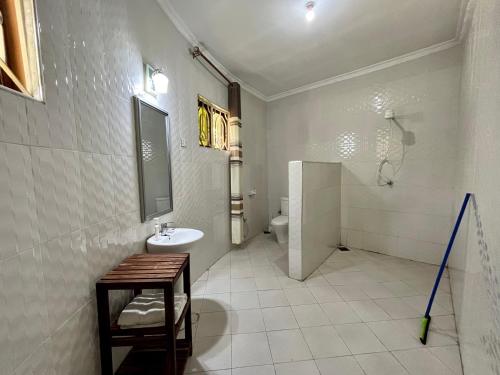 a white bathroom with a sink and a toilet at Charming Bungalows in Mwanza