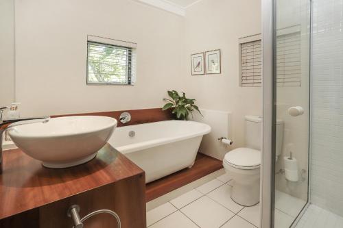 a bathroom with a tub and a toilet and a sink at Elgin Country Cottage in Elgin
