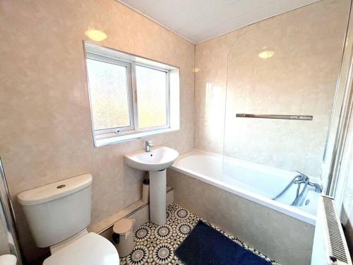 a bathroom with a toilet and a sink and a tub at 3 bedroom house near the city in Gateshead