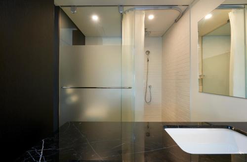 a bathroom with a shower and a sink and a tub at Sotetsu Hotels The Splaisir Seoul Myeongdong in Seoul