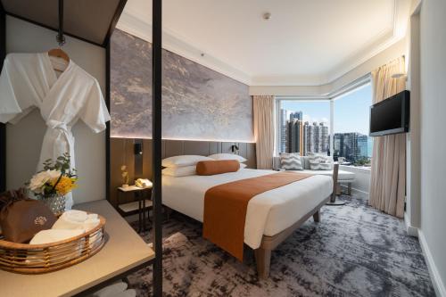 pokój hotelowy z łóżkiem i dużym oknem w obiekcie Harbour Plaza Metropolis w Hongkongu