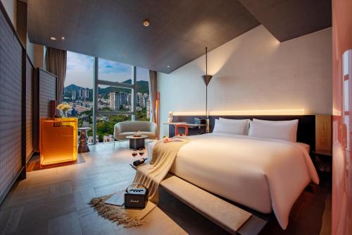 um quarto com uma cama grande e uma janela grande em Grade Hotel Shenzhen Shekou Sea World em Shekou