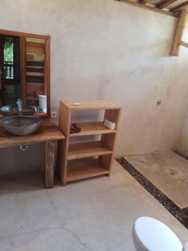 a bathroom with a sink and a wooden table at Ocean Prana Village in Amed