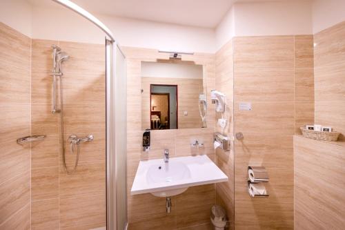 W łazience znajduje się umywalka i prysznic. w obiekcie Hotel Meteor Plaza Prague w Pradze