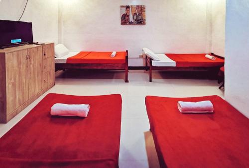 a room with two red rugs and a tv at Sunrise Garden Lake Resort in Lahit