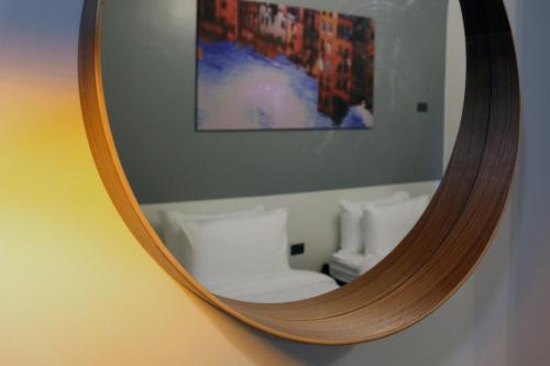 a mirror on a wall with a reflection of a room at mySTAY Hotel BGC North in Manila