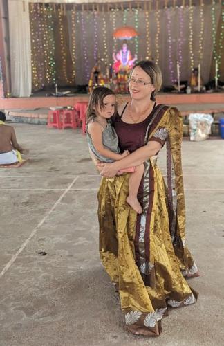 a woman holding a little girl on a dance floor at Mundro Garden Homestay in Munroe Island