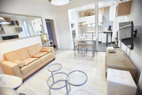 un salon avec un canapé et une table dans l'établissement Etretat - Centre plage - Gîte Les Vagues de l'Atlantide, à Étretat