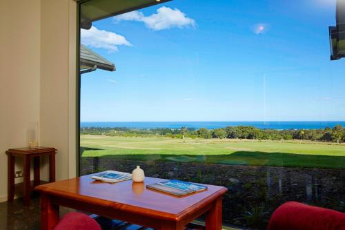a room with a table and a view of a golf course at Koura Bay Golf Resort in Kaikoura