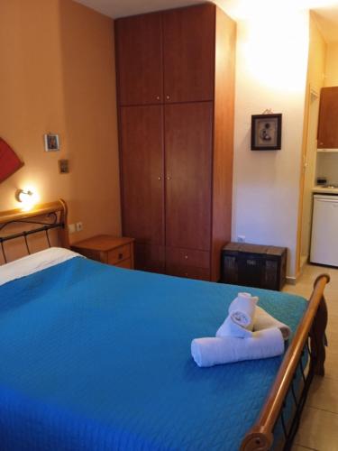 a bedroom with a blue bed with towels on it at Kouvaras Apartments in Kýthira