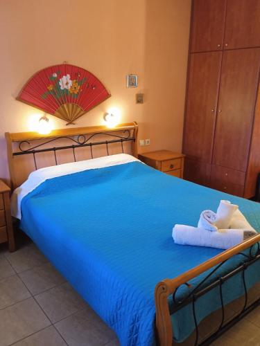 Un dormitorio con una cama azul con toallas. en Kouvaras Apartments en Kýthira