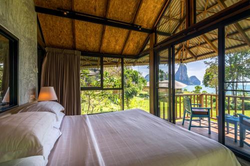 a bedroom with a large bed and a large window at Tinidee Hideaway Tonsai Beach Krabi - SHA Extra Plus in Tonsai Beach