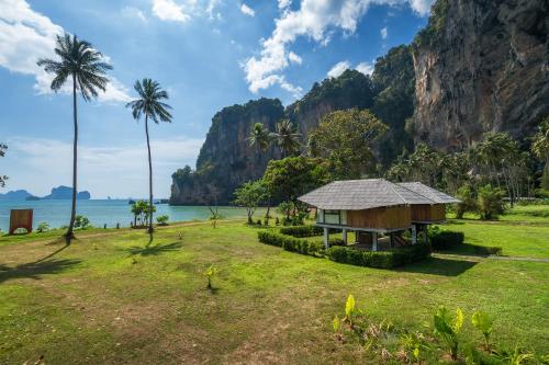 a small hut on a grass field next to the ocean at Tinidee Hideaway Tonsai Beach Krabi - SHA Extra Plus in Tonsai Beach
