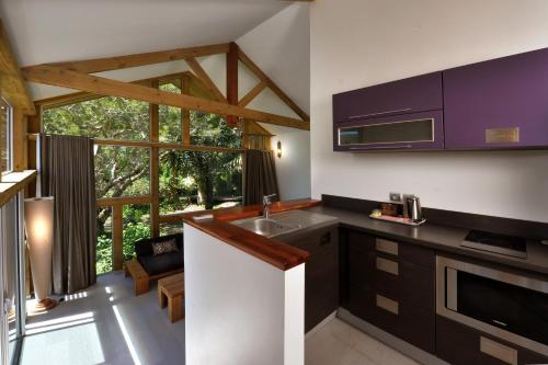 a kitchen with a sink and a stove top oven at Betikure Parc Lodge in Bourail