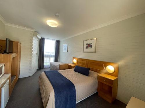 Habitación de hotel con 2 camas y 2 lámparas en Goulburn Motor Inn, en Goulburn