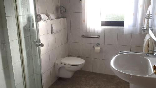 La salle de bains blanche est pourvue de toilettes et d'un lavabo. dans l'établissement Ferienwohnung mit Terrasse, kostenloses WLAN, Parkplatz, à Bad Oeynhausen