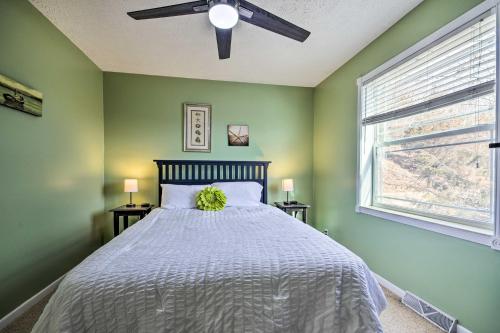 a bedroom with a bed with a ceiling fan and a window at Gravois Mills Home Boating Vacation! in Gravois Mills
