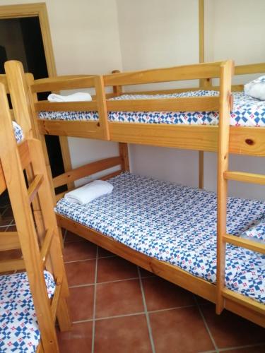 a room with three bunk beds in a room at Albergue La Pinilla in Madrid