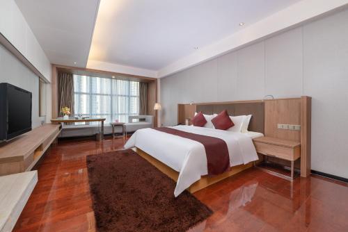 a bedroom with a large bed and a flat screen tv at Shenzhen Ramada Plaza, North Railway Station in Shenzhen