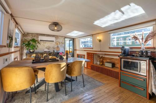 una cocina con una gran mesa de madera y sillas en The luxury Boat, en Zwolle