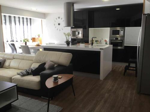 a living room with a couch and a kitchen at Gran piso alto LuzDiseño centrico con garaje in León