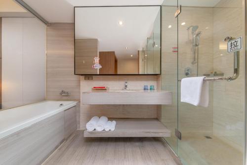 a bathroom with a sink and a shower at Shenzhen Ramada Plaza, North Railway Station in Shenzhen