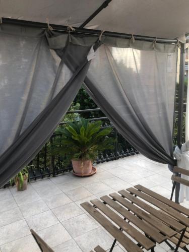 佩羅的住宿－Appartamento con terrazza e posto auto Libri e Giardini，庭院,庭院里设有窗帘、长凳和植物