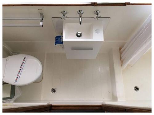 y baño con aseo, lavabo y pelota. en Caloundra Houseboats en Pelican Waters