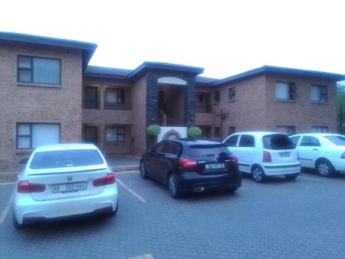 un grupo de autos estacionados en un estacionamiento frente a un edificio en Golf view place, en Empangeni
