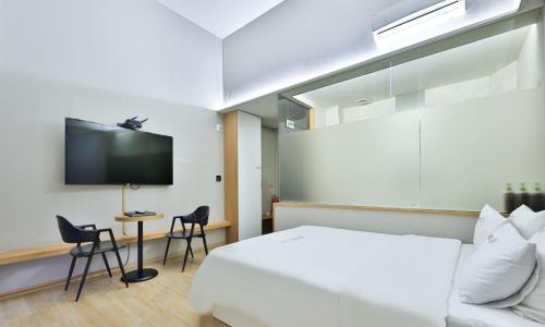 a hotel room with a bed and a tv at Hotel TAO in Seoul