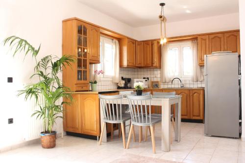 uma cozinha com armários de madeira e uma mesa e cadeiras em Moriana Stone Villa, panoramic view and garden em Lakíthra