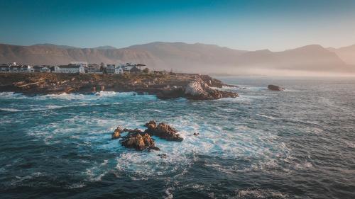 a view of the ocean with rocks in the water at Sixteen Guesthouse on Main in Hermanus