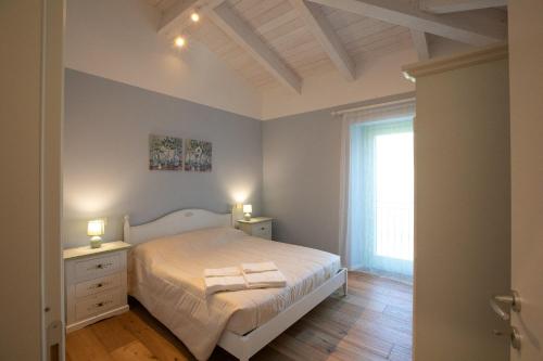 a bedroom with a white bed and a window at Agriturismo San Filippo Neri in Castignano