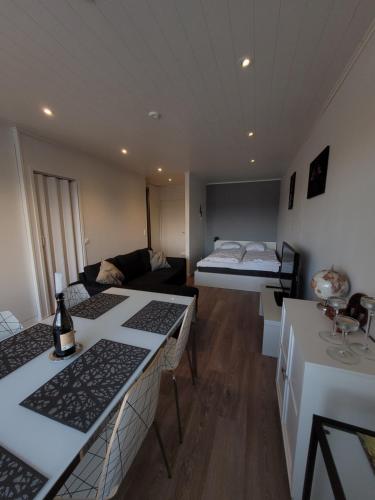 a living room with a bed and a room with tables at Topelius Park Apartment in Uusikaarlepyy