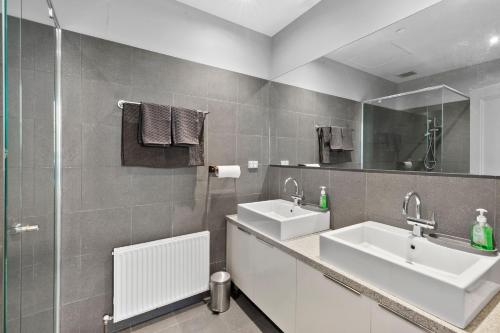 a bathroom with two sinks and a shower at Pelicans at the Ozone in Queenscliff