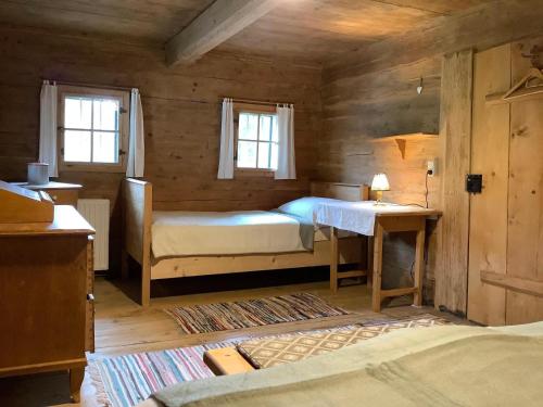 1 Schlafzimmer mit einem Bett, einem Schreibtisch und 2 Fenstern in der Unterkunft Ferienhaus Lindaubachgütl in Fieberbrunn