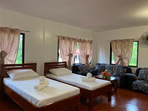 a living room with two beds and a couch at Tongatok Cliff Resort in Mambajao